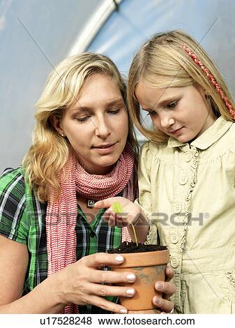 Stock Photo - Mother and daughter planting flower. Fotosearch
