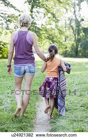 Stock Image - mother and daughter walking together. Fotosearch