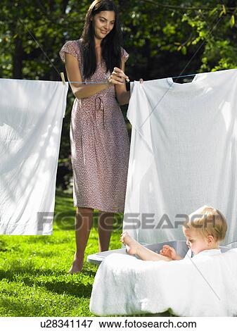 Stock Photo - Mother and son doing the laundry. Fotosearch