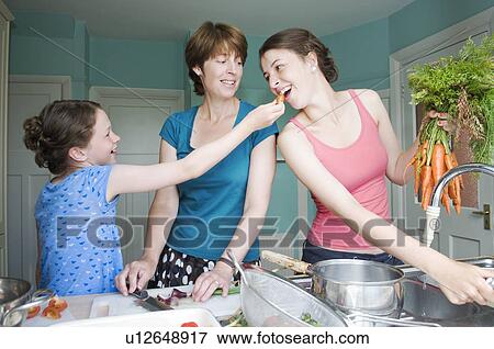 Stock Photo - Mother cooking with her two daughters. Fotosearch