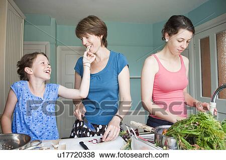 Stock Photo - Mother cooking with her two daughters. Fotosearch