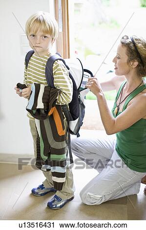 Stock Image - mother getting her son ready for school. Fotosearch