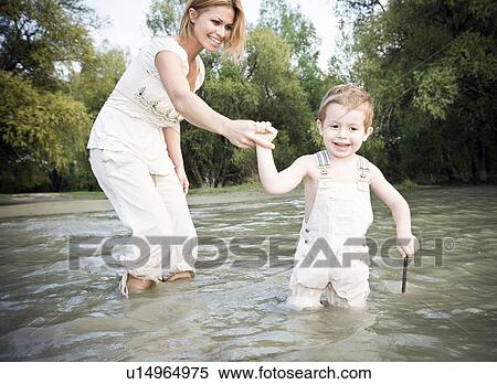 Stock Photography - Mother holding childs hand in water. Fotosearch