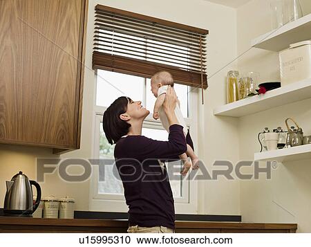 Mother holding her baby up in the air View Large Photo Image Stock Image - Mother holding her baby up in the air. Fotosearch