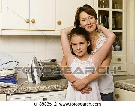 Stock Image - Mother hugging her daughter. Fotosearch