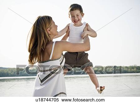 Mother lifting child in air View Large Photo Image Stock Photography - Mother lifting child in air. Fotosearch