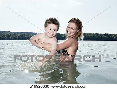 Mother lifting child in water View Large Photo Image Stock Image - Mother lifting child in water. Fotosearch