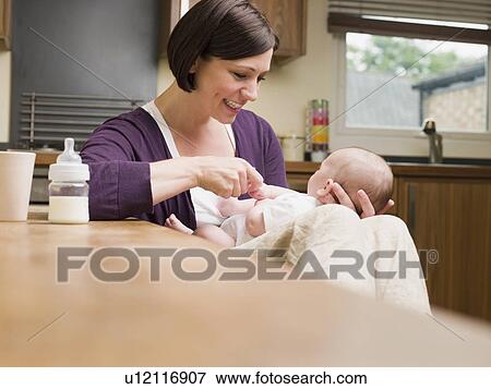 Mother sat playing with her baby View Large Photo Image Stock Photo - Mother sat playing with her baby. Fotosearch