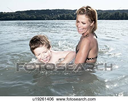 Stock Photograph - Mother teaching child to swim. Fotosearch