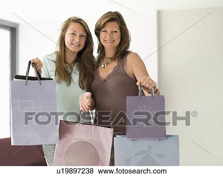 Stock Photo - mum and daughter with shopping bags. Fotosearch
