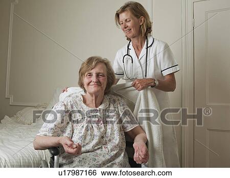 Nurse assisting elderly woman View Large Photo Image Stock Photograph - Nurse assisting elderly woman. Fotosearch