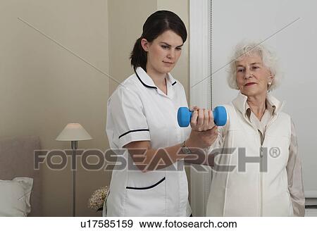 Stock Photo - Nurse helping woman with exercises. Fotosearch
