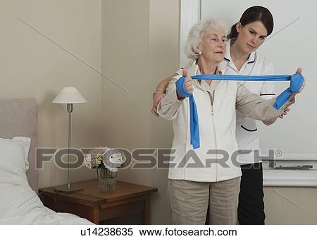 Nurse helping woman with exercises View Large Photo Image Stock Photography - Nurse helping woman with exercises. Fotosearch