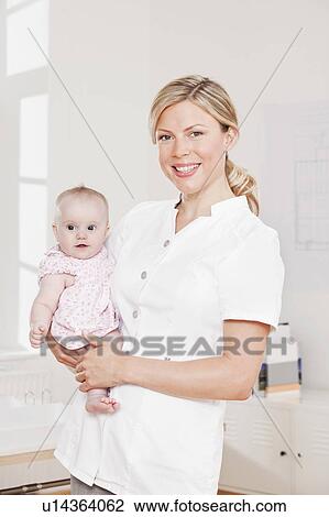 Nurse holding a baby View Large Photo Image Stock Image - Nurse holding a baby. Fotosearch