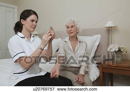 Stock Photo - Nurse preparing injection for woman. Fotosearch