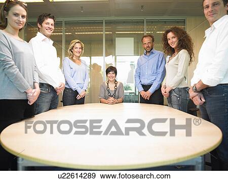 Stock Photo - People around a table, smiling. Fotosearch