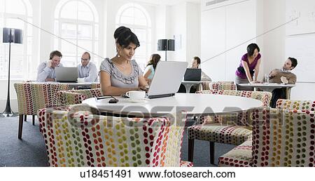 Stock Image - People working on laptops in office. Fotosearch