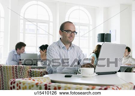 Stock Photograph - People working on laptops in office. Fotosearch