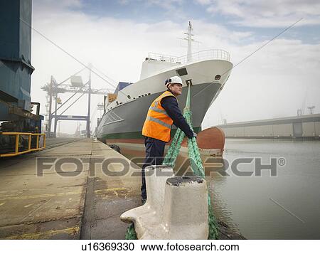 Stock Image - Port Worker With Container Ship. Fotosearch
