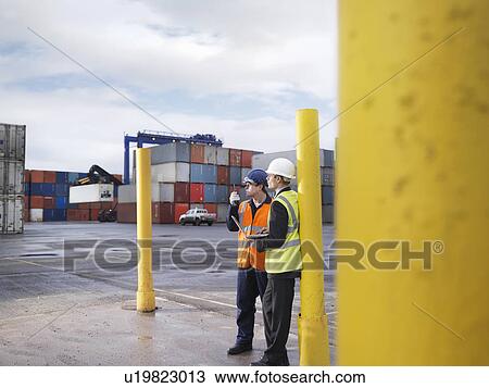 Stock Image - Port Workers With Laptop And Containers. Fotosearch