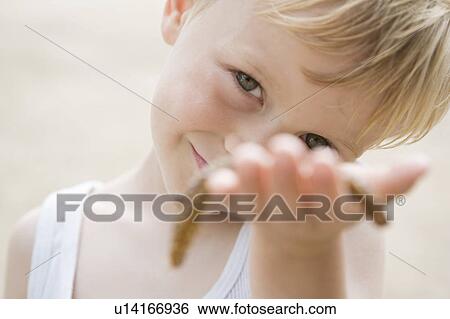 Stock Photograph - Portrait of a boy with sea-asterisk. Fotosearch