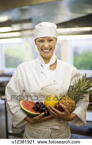 Stock Image - Portrait of a female chef with fruit. Fotosearch