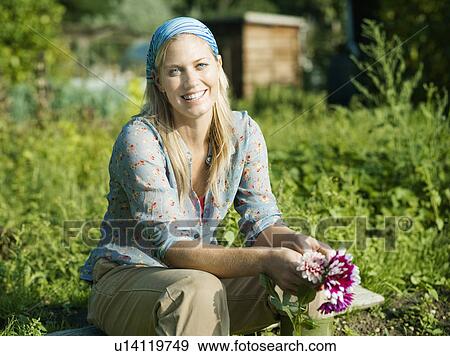 Stock Photo - Portrait of a woman sat in a garden. Fotosearch