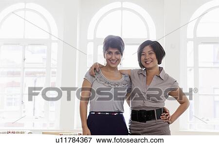 Portrait of two young females in office View Large Photo Image Stock Photo - Portrait of two young females in office. Fotosearch