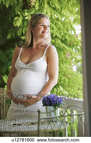 Stock Image - pregnant woman on balcony. Fotosearch