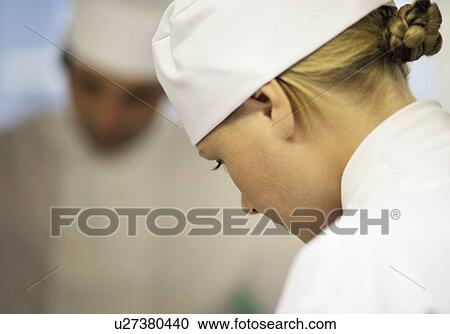 Stock Image - Profile of a female chef working. Fotosearch