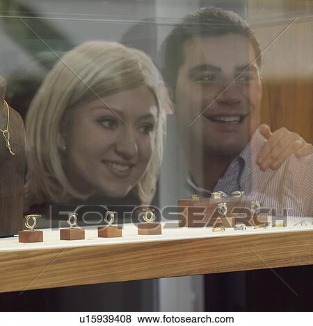 Stock Photo - reflection of couple on shop window. Fotosearch
