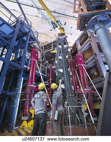 Stock Photo - Scientists Discussing Fusion Reactor. Fotosearch