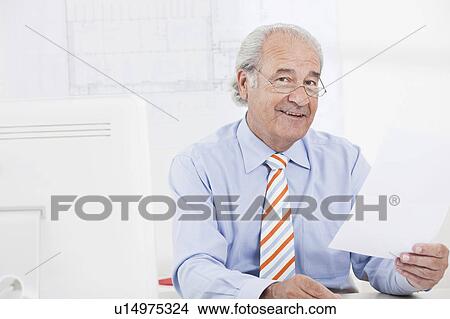 Senior businessman reading a paper View Large Photo Image Picture - Senior businessman reading a paper. Fotosearch