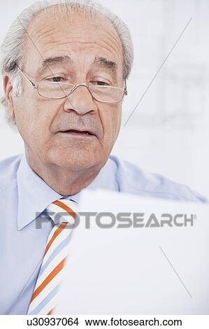 Senior businessman reading a paper View Large Photo Image Picture - Senior businessman reading a paper. Fotosearch