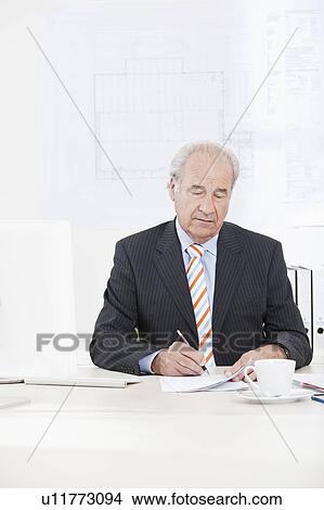 Picture - Senior businessman signing document. Fotosearch