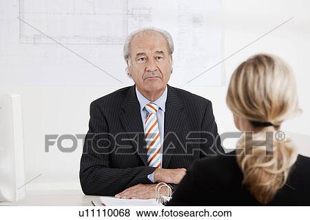 Senior businessman talking to a woman View Large Photo Image Stock Photo - Senior businessman talking to a woman. Fotosearch