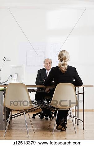 Senior businessman talking to a woman View Large Photo Image Stock Photo - Senior businessman talking to a woman. Fotosearch
