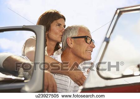 Stock Photography - Senior couple embracing in sports car. Fotosearch