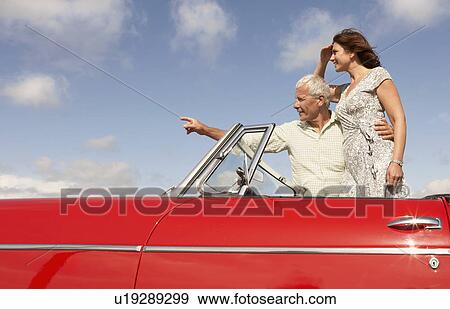 Senior couple in sports car, pointing View Large Photo Image Stock Photo - Senior couple in sports car, pointing. Fotosearch