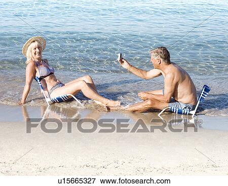 Stock Photo - Senior male taking a photo of a woman. Fotosearch
