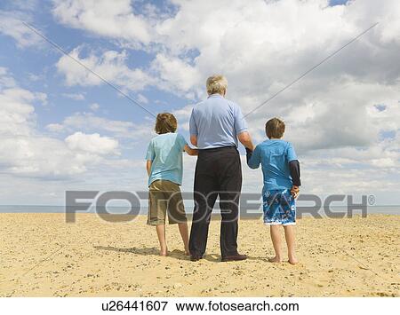 Senior man and 2 boys looking out to sea View Large Photo Image Stock Photo - Senior man and 2 boys looking out to sea. Fotosearch
