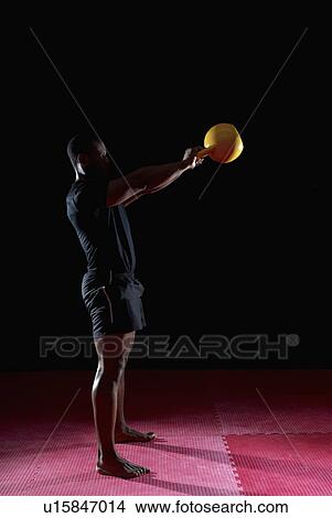 side view of man raising kettle bell View Large Photo Image Picture - side view of man raising kettle bell. Fotosearch