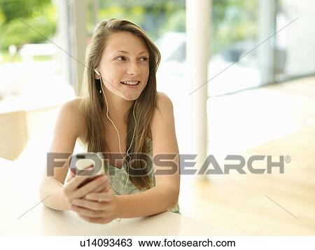 Stock Image - smiling girl listens to mp3 player. Fotosearch
