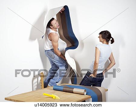 Smiling man struggling with wallpaper View Large Photo Image Stock Image - Smiling man struggling with wallpaper. Fotosearch