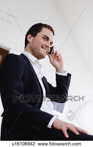 Stock Image - smiling man using cell phone. Fotosearch