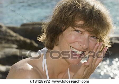 Stock Image - Smiling woman in the sun. Fotosearch