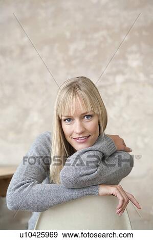 Stock Photo - smiling woman sitting on chair. Fotosearch