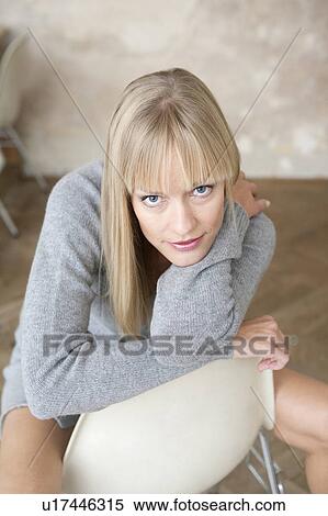 Stock Photography - smiling woman sitting on chair. Fotosearch