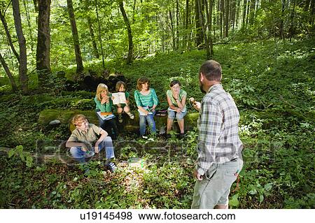 Stock Photo - teacher and pupils at the wood. Fotosearch