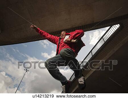 Stock Photo - teenage boy jumping with books. Fotosearch